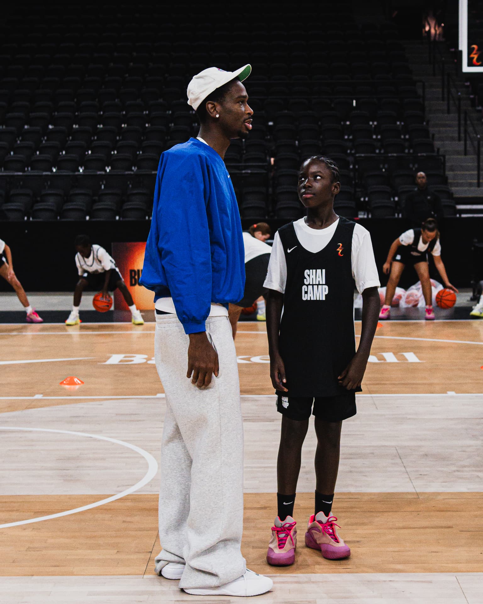 Shai Gilgeous-Alexander standing with a young athlete at SGA Camp