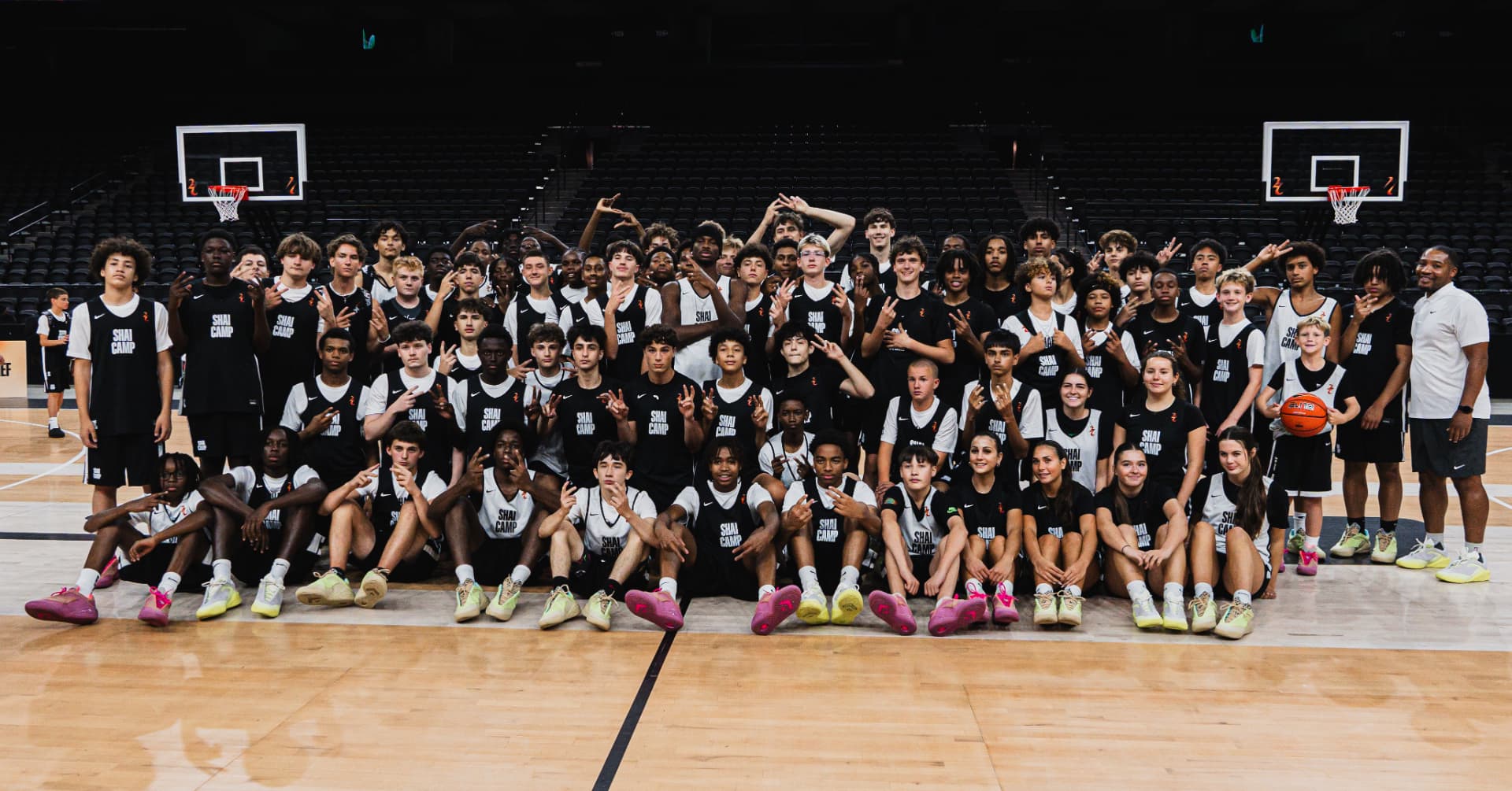 A large group of young athletes and coaches gathered on the court at SGA Camp